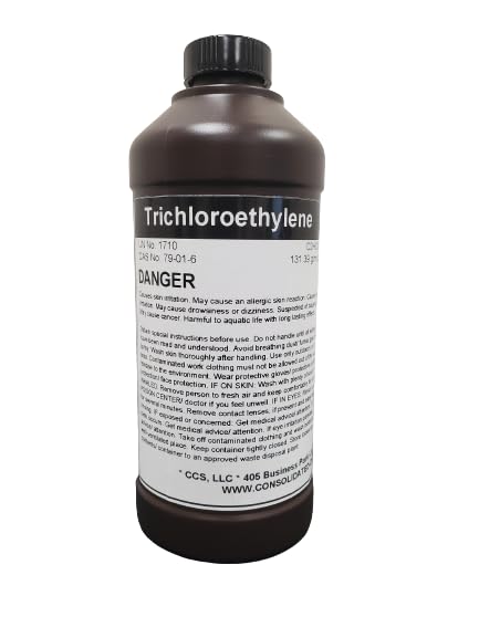 Brown bottle of trichloroethylene with warning label.